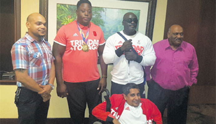 WELL DONE! Proud members of the T&T Paralympic Association, from second left: Akeem Stewart, Carlos Greene, Pradeep Vishnu and Sudhir Ramessar (front) at the VIP Lounge of the Piarco International Airport on Monday night with Ronson Hackshaw, the Assistant Director, Physical Education of the Ministry of Sports and Youth Affairs.